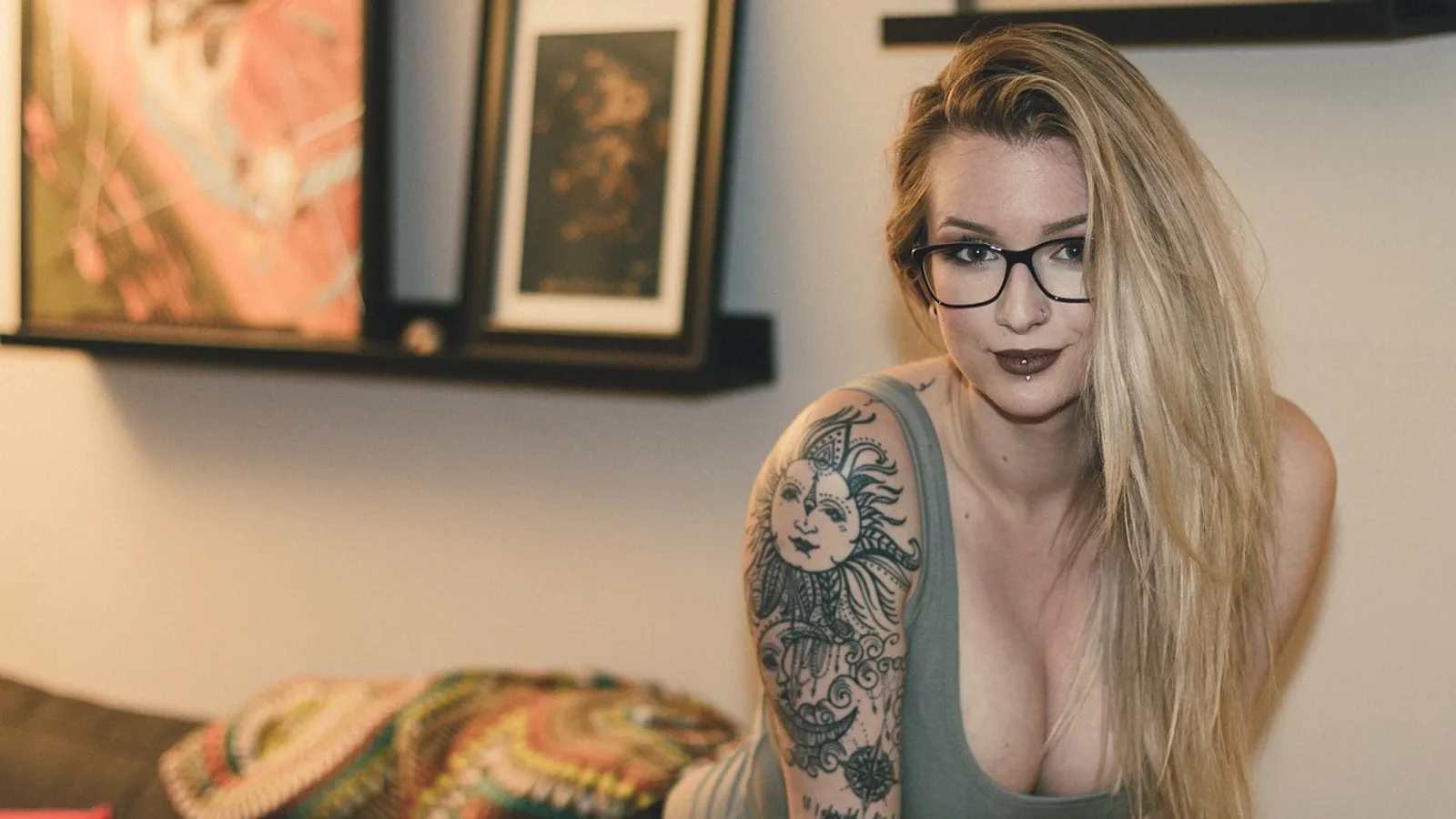 Tatuerad blond kvinna i linne och glasögon